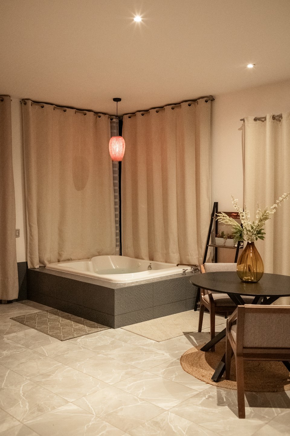 Interno di una suite d'albergo con vasca idromassaggio e zona pranzo.