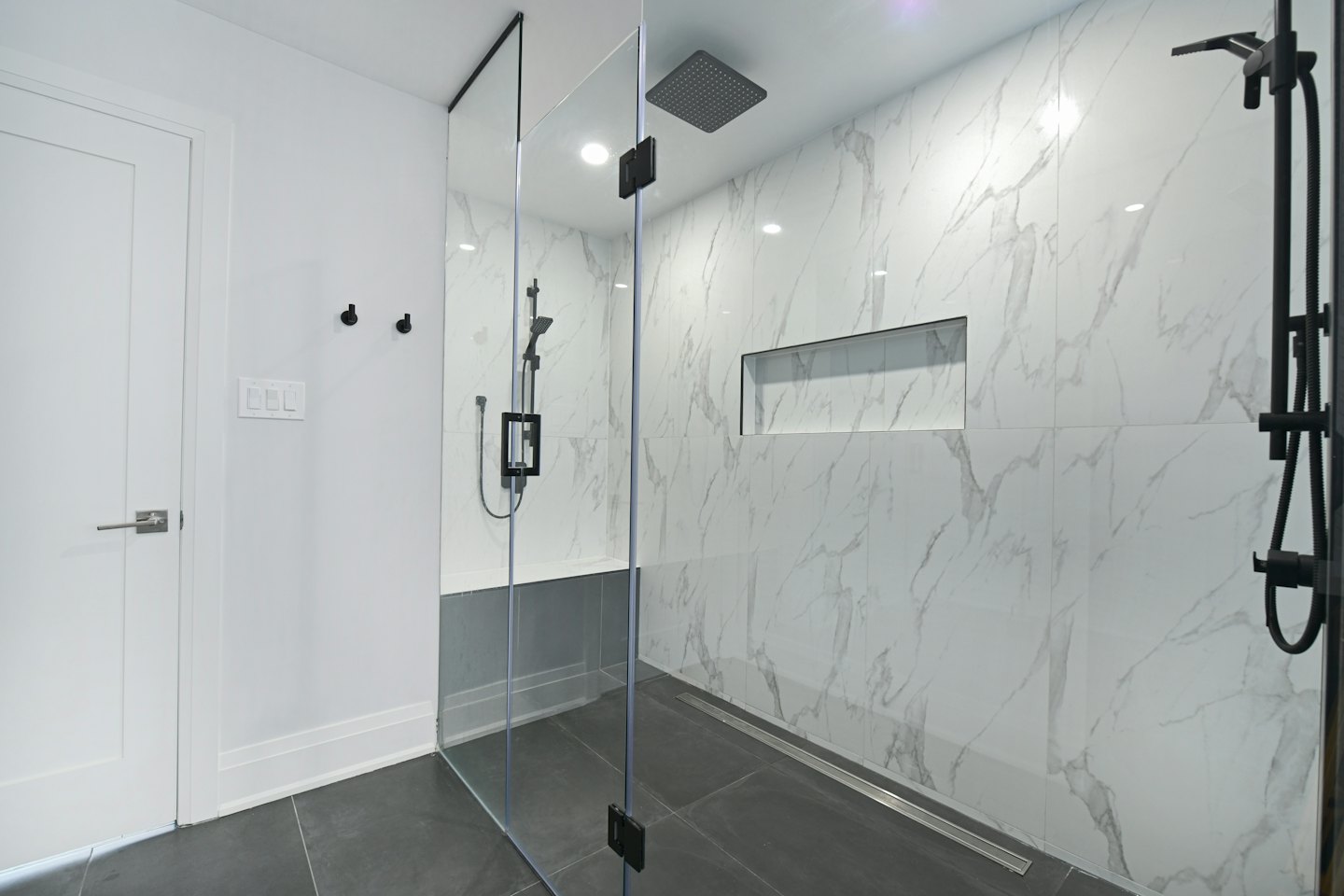 Bagno moderno con doccia in marmo a tutta parete.